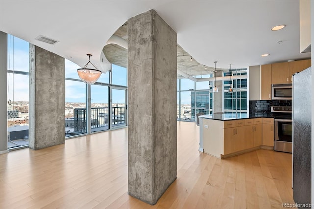 kitchen with decorative light fixtures, light hardwood / wood-style flooring, light brown cabinetry, floor to ceiling windows, and appliances with stainless steel finishes