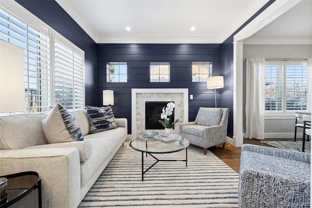 living room with ornamental molding, a high end fireplace, and wood-type flooring