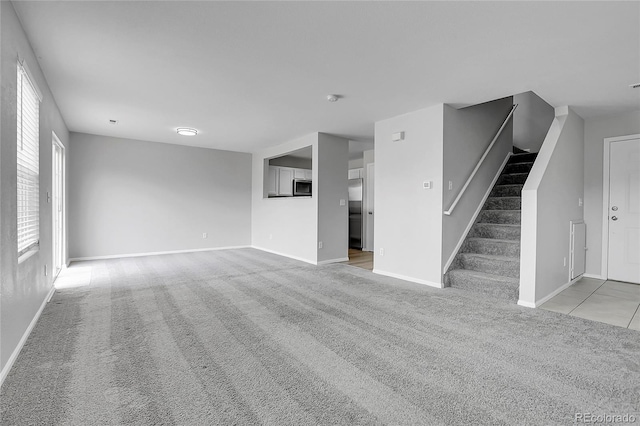 7977 S Kittredge St, Englewood, CO 80112 - unfurnished living room with light colored carpet and stairway