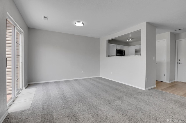 7977 S Kittredge St, Englewood, CO 80112 - unfurnished living room featuring light colored carpet and baseboards