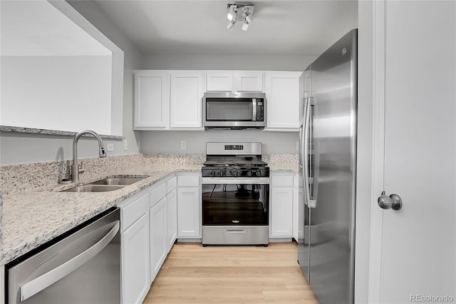 7977 S Kittredge St, Englewood, CO 80112 - kitchen with stainless steel appliances, white cabinetry, light stone counters, and light wood finished floors