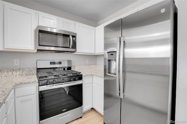 7977 S Kittredge St, Englewood, CO 80112 - kitchen with appliances with stainless steel finishes, white cabinets, and light stone countertops