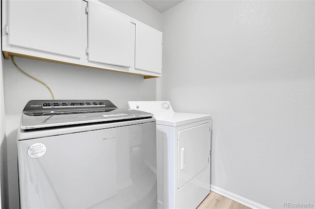 7977 S Kittredge St, Englewood, CO 80112 - laundry area with cabinet space, washer and clothes dryer, and light wood-style floors