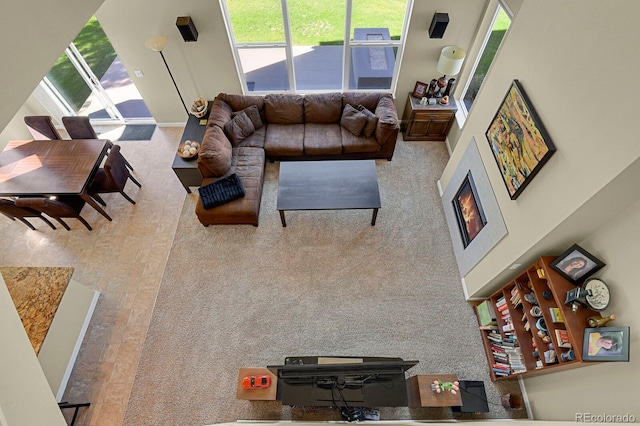 carpeted living room featuring a high ceiling