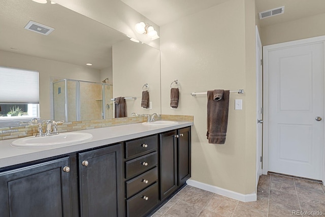 bathroom with vanity, tasteful backsplash, an enclosed shower, and tile patterned floors