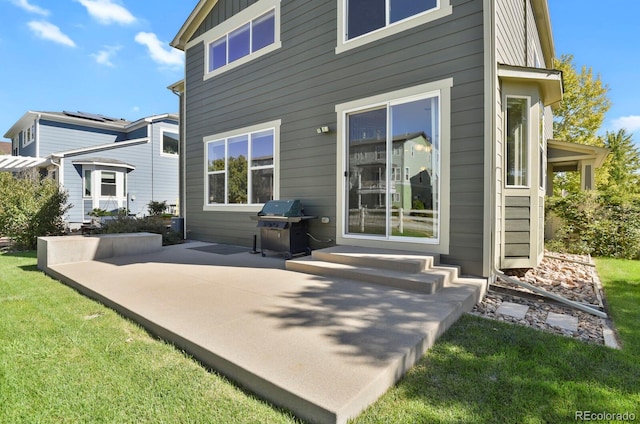 back of house featuring a lawn and a patio