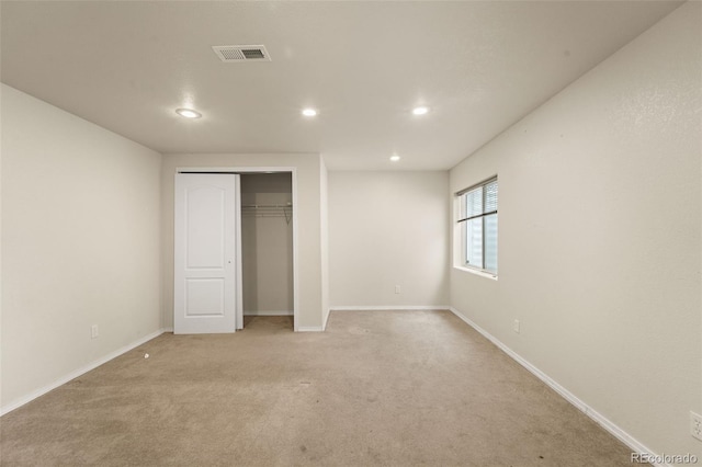unfurnished bedroom featuring visible vents, baseboards, a closet, recessed lighting, and light colored carpet