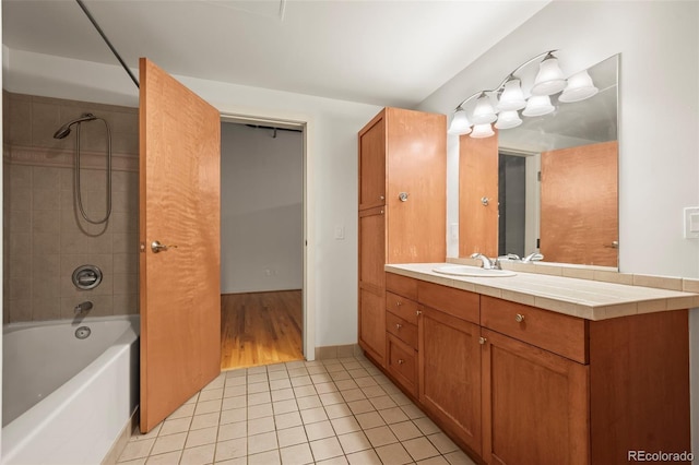 bathroom with tiled shower / bath combo, vanity, and tile patterned floors