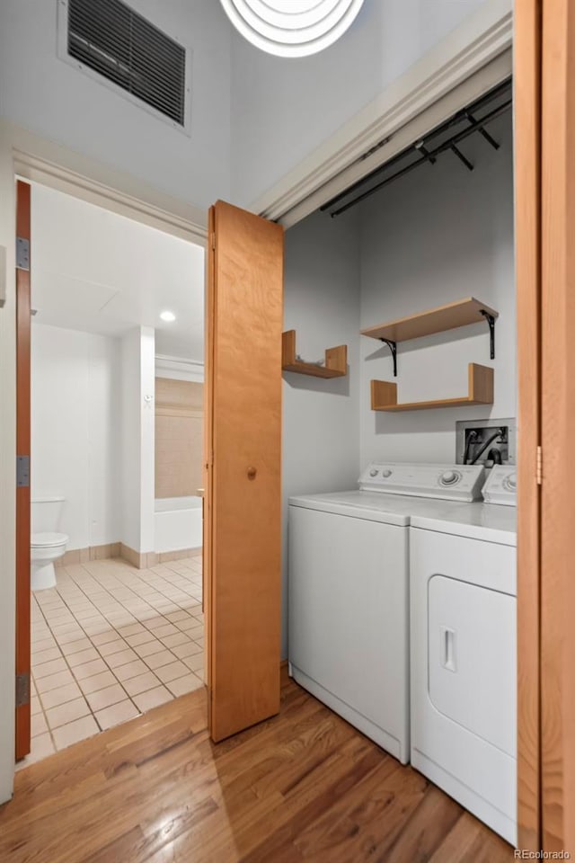 1800 Lawrence St Unit 408, Denver, CO 80202 - laundry area with washer and dryer and light wood-style floors