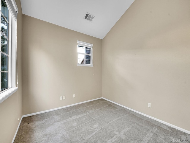 unfurnished room with vaulted ceiling and carpet floors