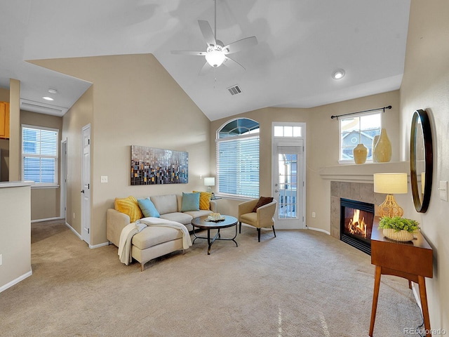 living room featuring ceiling fan, light colored carpet, plenty of natural light, and a fireplace