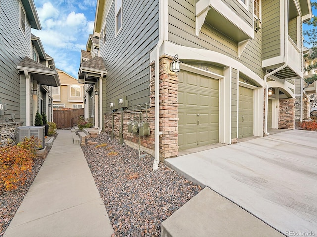 view of property exterior with a garage and central air condition unit