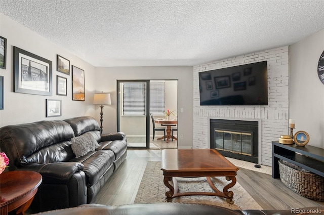 534 E 7th Ave Unit 206, Denver, CO 80203 - living room featuring wood finished floors, a fireplace, and a textured ceiling