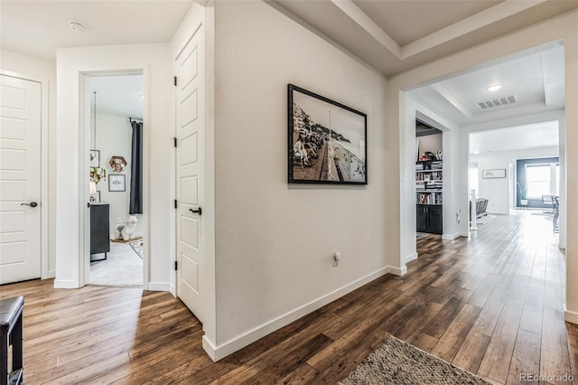 hall featuring a tray ceiling and hardwood / wood-style floors