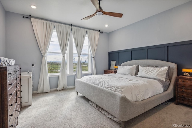 carpeted bedroom featuring ceiling fan and multiple windows