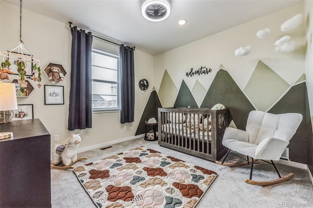 bedroom featuring a crib and light carpet