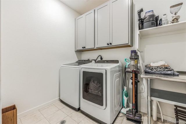 washroom with cabinets, light tile patterned flooring, and washer and dryer