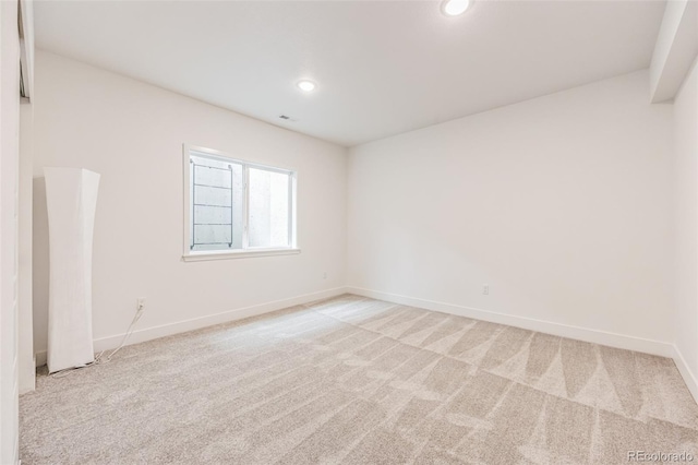 spare room featuring light carpet