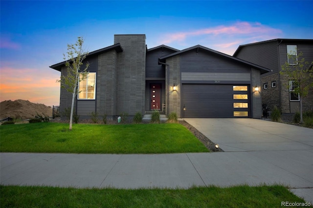 view of front of home with a garage and a lawn