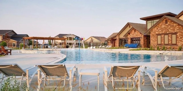 view of pool featuring a patio area, pool water feature, and a jacuzzi