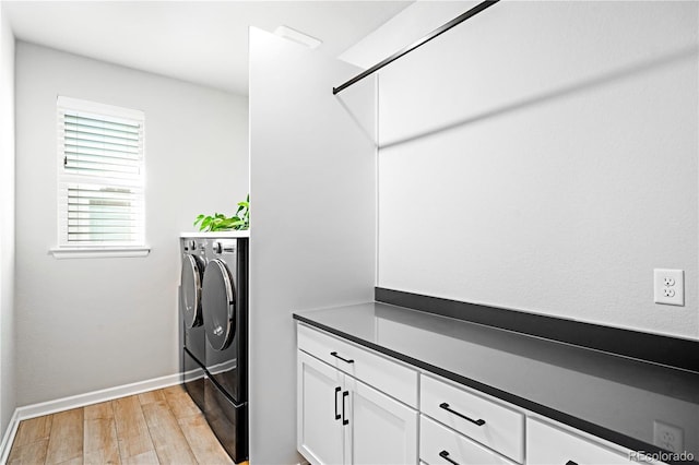 laundry room with washing machine and clothes dryer and light hardwood / wood-style floors