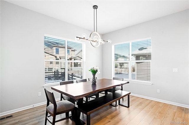 dining room featuring wood-type flooring and a chandelier