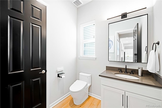 bathroom featuring hardwood / wood-style flooring, vanity, and toilet