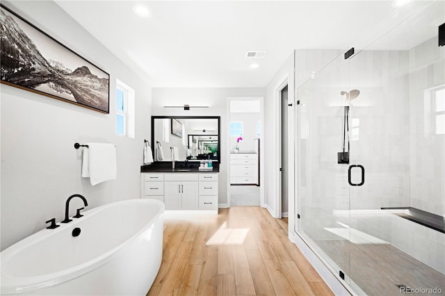 bathroom featuring separate shower and tub, hardwood / wood-style floors, and vanity