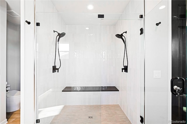 bathroom with hardwood / wood-style flooring, toilet, and walk in shower