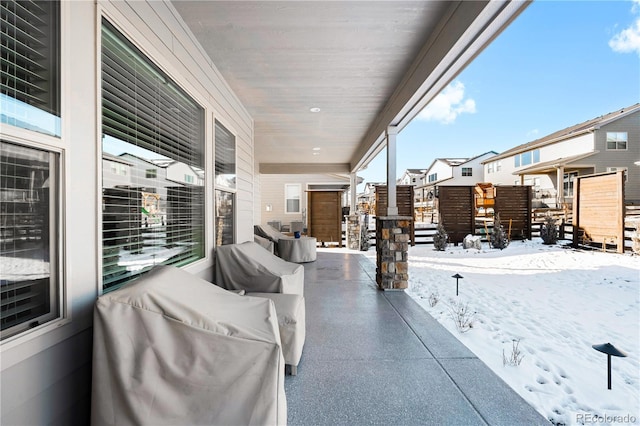 snow covered patio with a grill