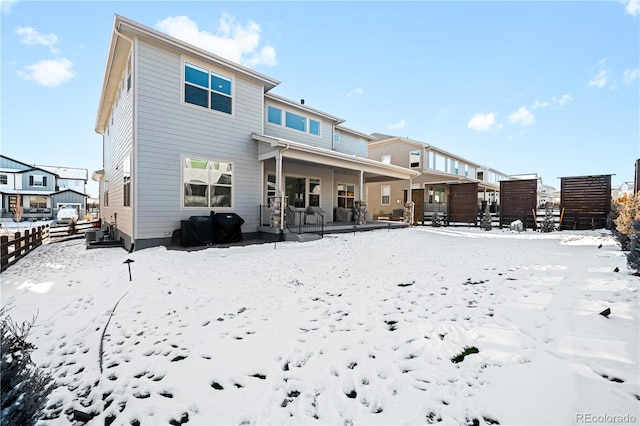 snow covered house featuring a porch