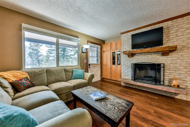 living room with a brick fireplace, dark hardwood / wood-style floors, and a textured ceiling