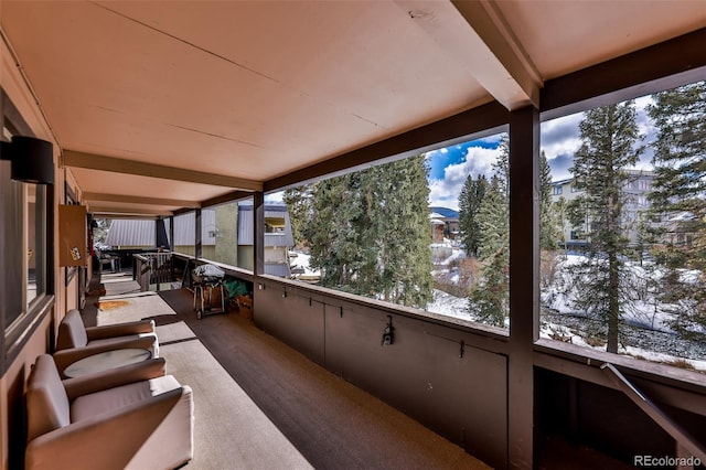 unfurnished sunroom with plenty of natural light and beamed ceiling