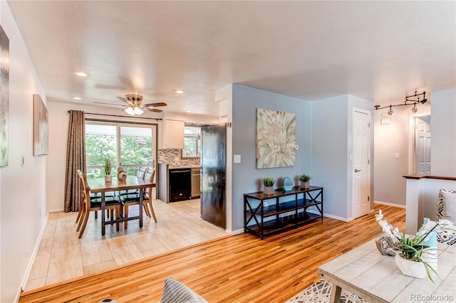 living room featuring light wood-type flooring, baseboards, a ceiling fan, and recessed lighting
