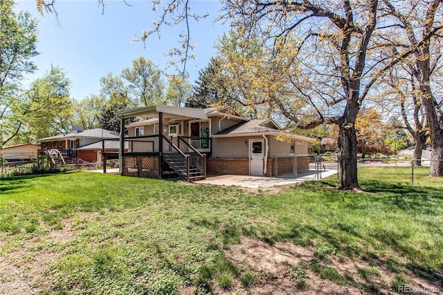 rear view of house featuring stairs, brick siding, a deck, and a patio area