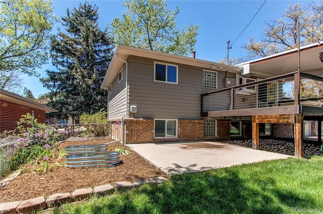 rear view of house with a patio area, brick siding, and a wooden deck