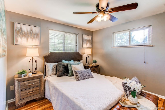 bedroom featuring wood finished floors, baseboards, and ceiling fan