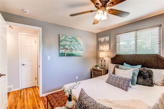 bedroom featuring light wood-style flooring, baseboards, and a ceiling fan