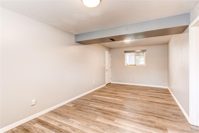 empty room with baseboards and light wood-style flooring
