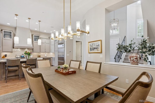 7834 Vallagio Ln, Englewood, CO 80112 - dining room featuring a chandelier, light wood-type flooring, recessed lighting, and stairway