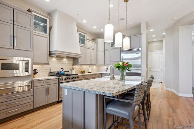 7834 Vallagio Ln, Englewood, CO 80112 - kitchen with built in appliances, a warming drawer, gray cabinets, custom range hood, and recessed lighting