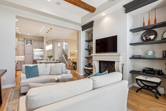 7834 Vallagio Ln, Englewood, CO 80112 - living room with light wood-style flooring, recessed lighting, a glass covered fireplace, beam ceiling, and stairway