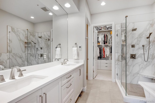 7834 Vallagio Ln, Englewood, CO 80112 - bathroom featuring a marble finish shower, double vanity, a walk in closet, recessed lighting, and tile patterned floors