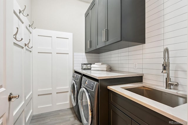 7834 Vallagio Ln, Englewood, CO 80112 - washroom featuring cabinet space, washer and dryer, and light wood finished floors
