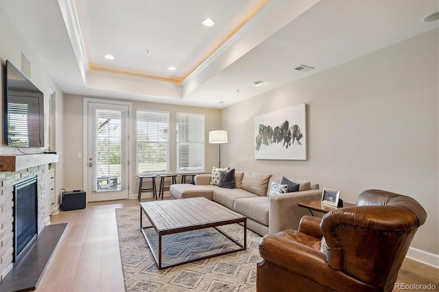 7834 Vallagio Ln, Englewood, CO 80112 - living room with a stone fireplace, a raised ceiling, recessed lighting, light wood-type flooring, and wine cooler