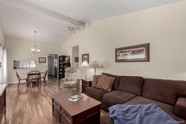 living area with baseboards, beam ceiling, ceiling fan with notable chandelier, wood finished floors, and a textured ceiling