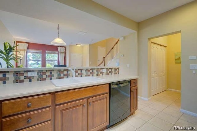 kitchen featuring decorative light fixtures, black dishwasher, sink, decorative backsplash, and light tile patterned floors