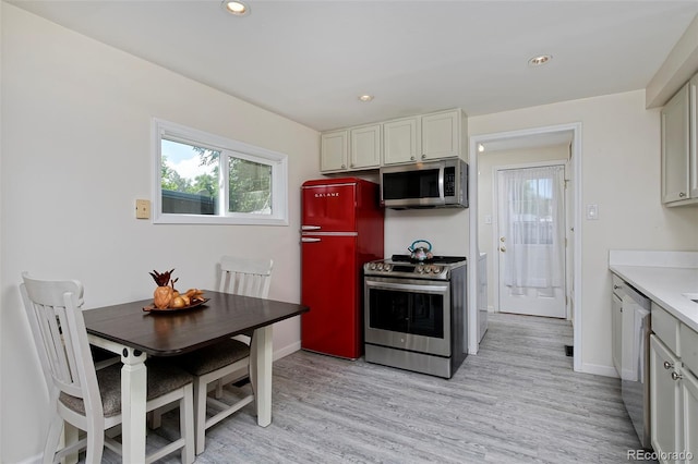 kitchen with light wood finished floors, light countertops, appliances with stainless steel finishes, and white cabinets