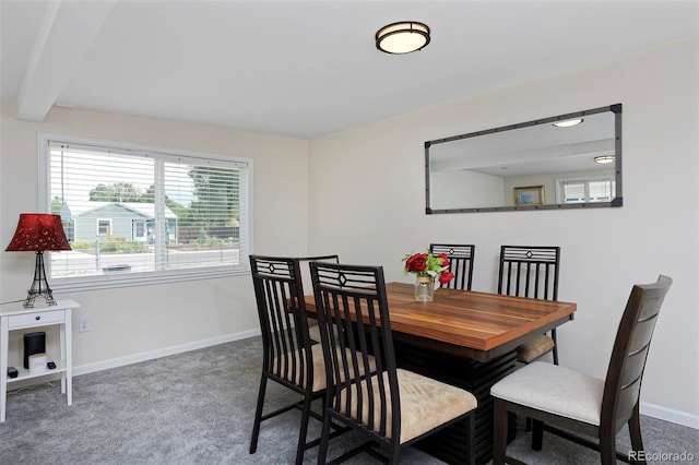 carpeted dining space with baseboards