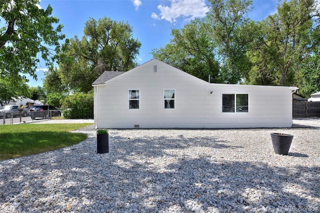 back of house featuring crawl space and fence